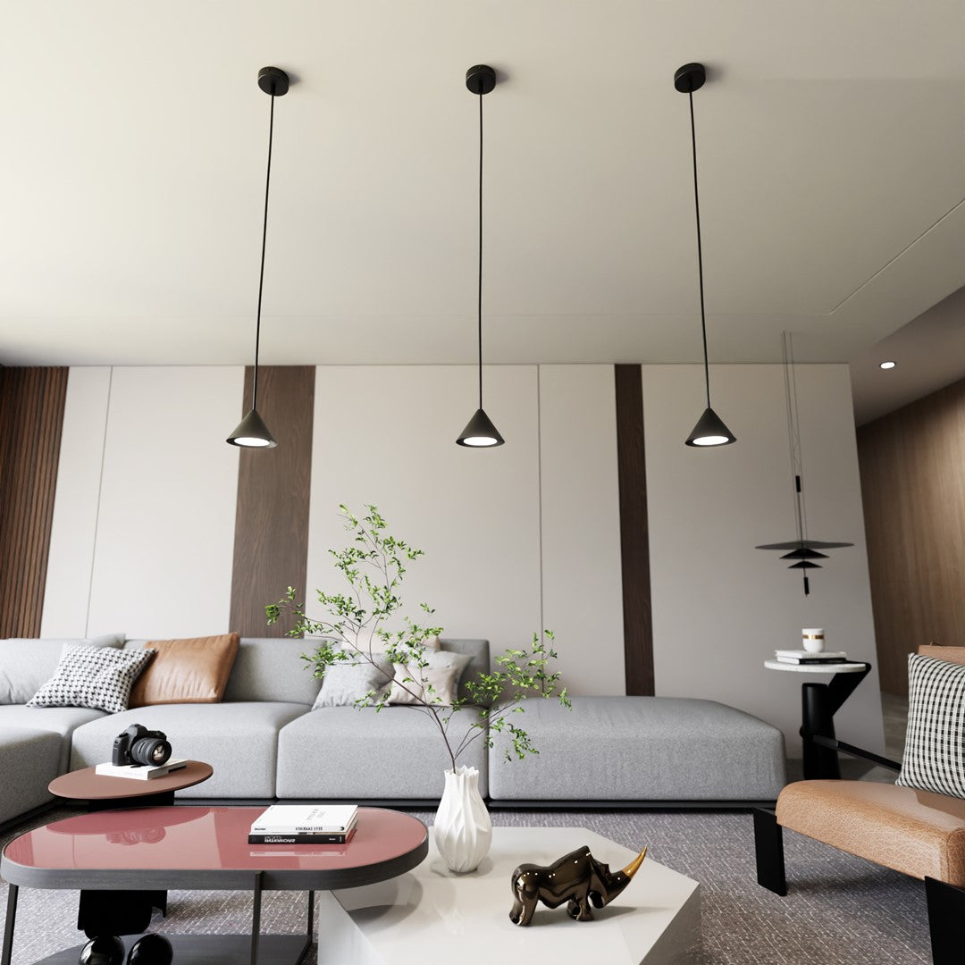 Trois suspensions noires alignées au plafond au-dessus d'un salon gris et beige