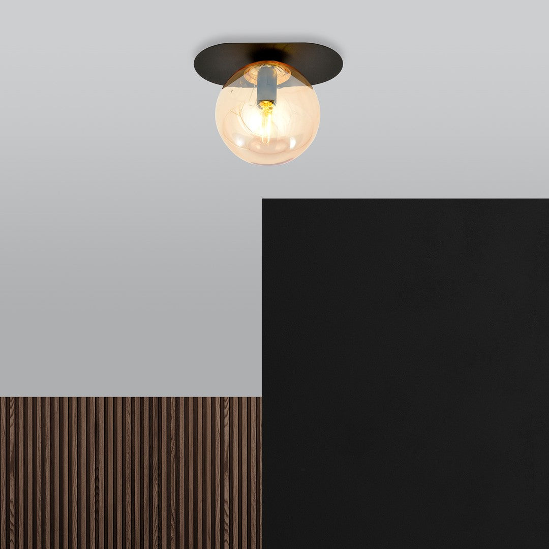Luminaire fixé au plafond devant un mur noir et un habillage bois