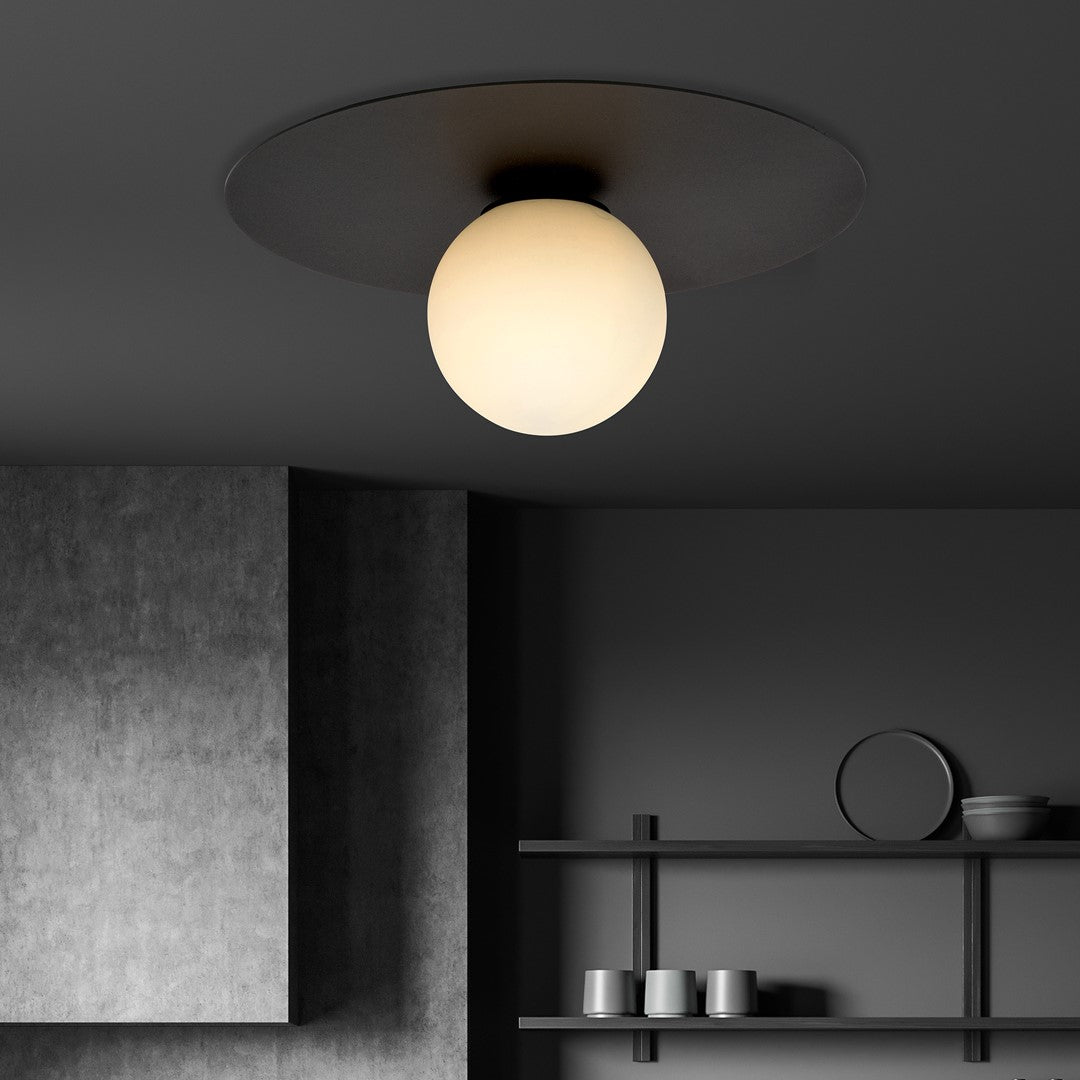 Ambiance sombre sur béton gris avec étagères et tasses, plafonnier allumé au plafond.