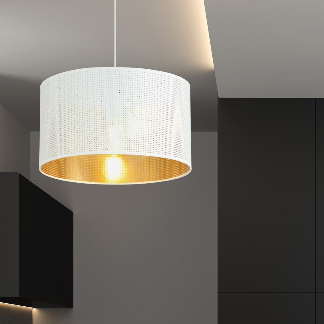 Suspension cylindrique éclairée dans une pièce sombre, abat-jour blanc perforé et reflet doré