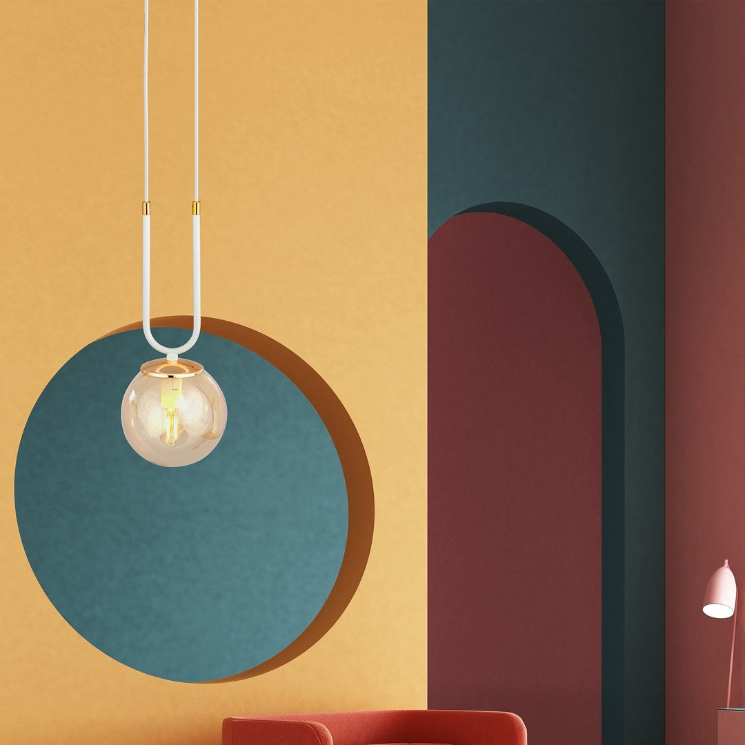 Suspension au-dessus d'un canapé rouge devant un décor graphique coloré.