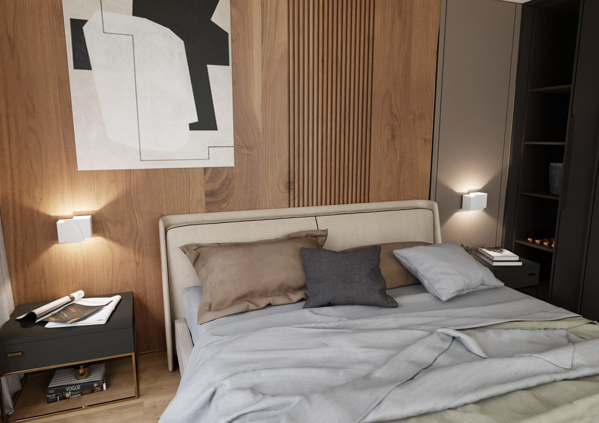 Chambre avec deux appliques murales blanches allumées de chaque côté de la tête de lit.