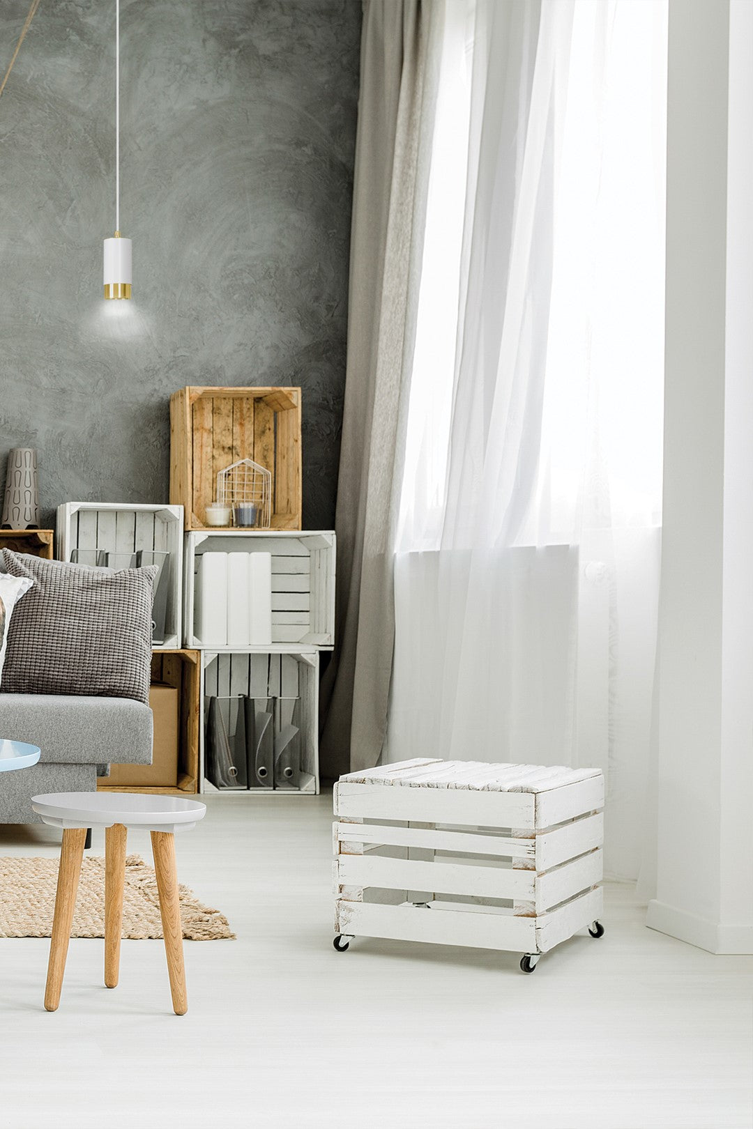 Mise en ambiance salon, suspension au-dessus d'une table basse et de caisses