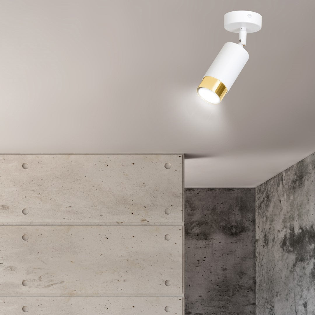 Vue rapprochée du spot allumé devant mur béton brut et plafond clair