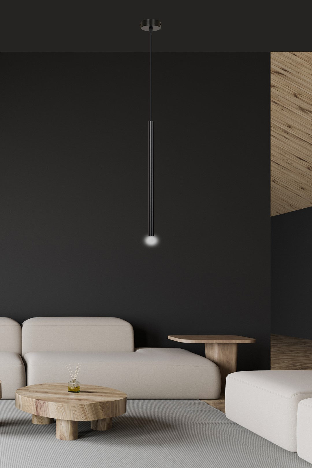 Mise en ambiance salon contemporain, suspension noire allumée au-dessus d'un canapé beige.