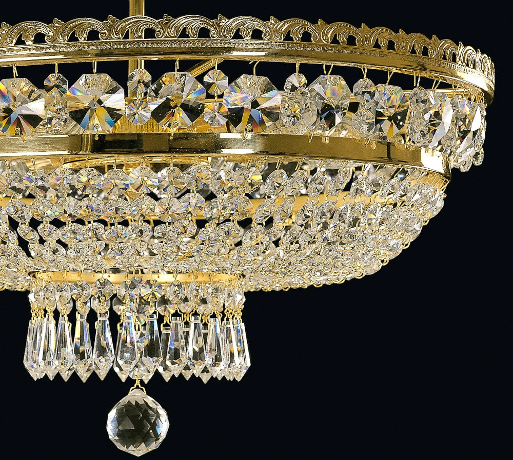 Détail du bas du luminaire doré avec pampilles et boule de cristal