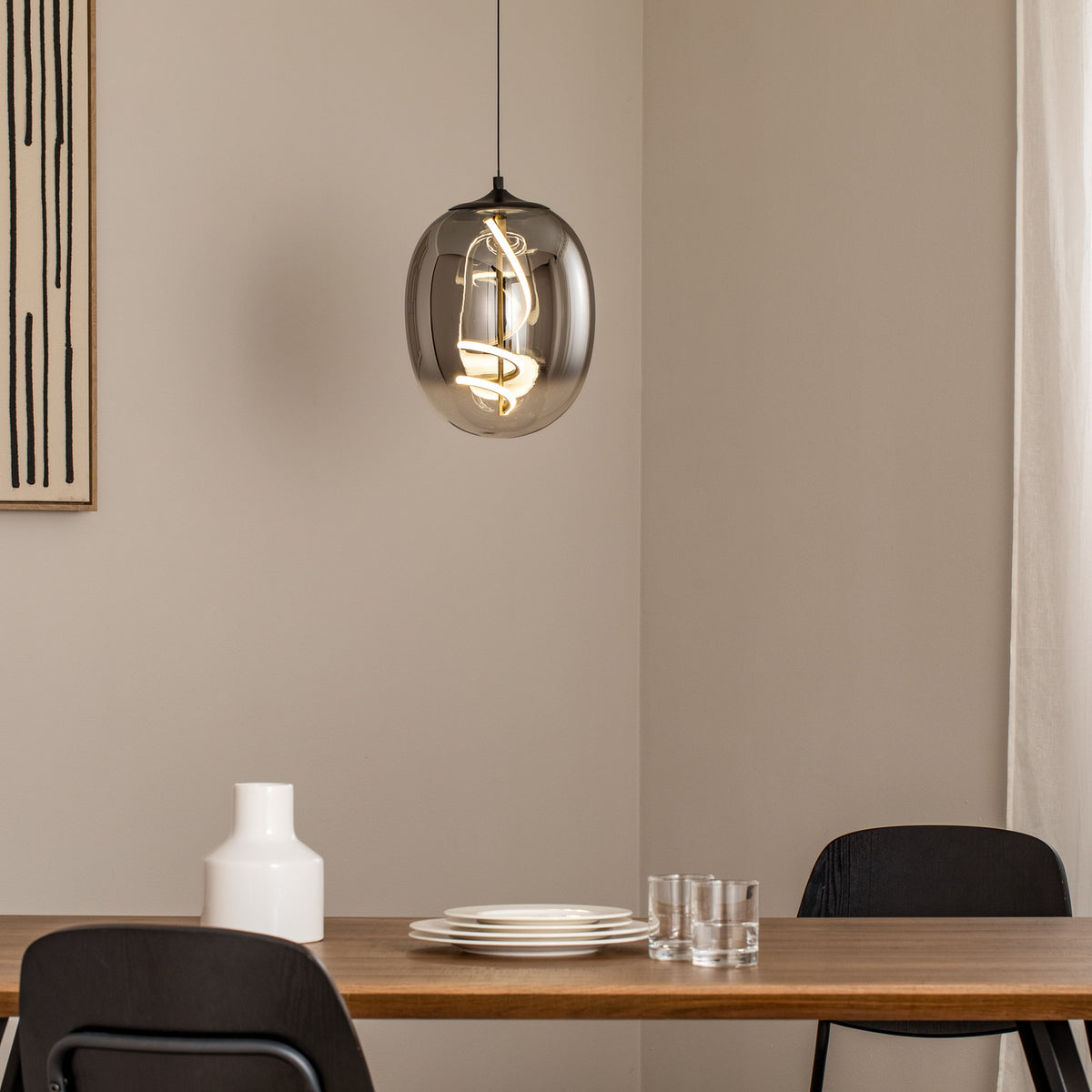 Suspension grise allumée au-dessus d’une table dressée dans une salle à manger.
