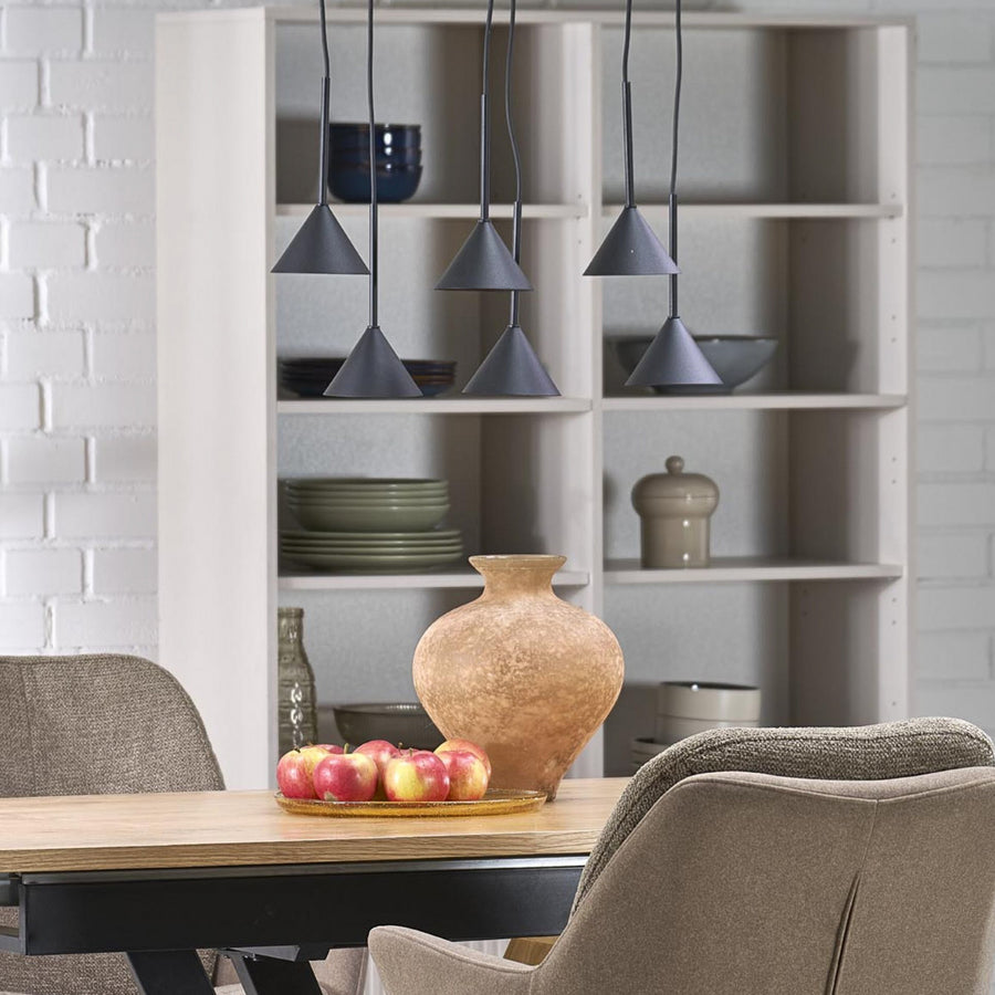 Suspension noire à six cônes installée au-dessus d'une table en bois dans une salle à manger.