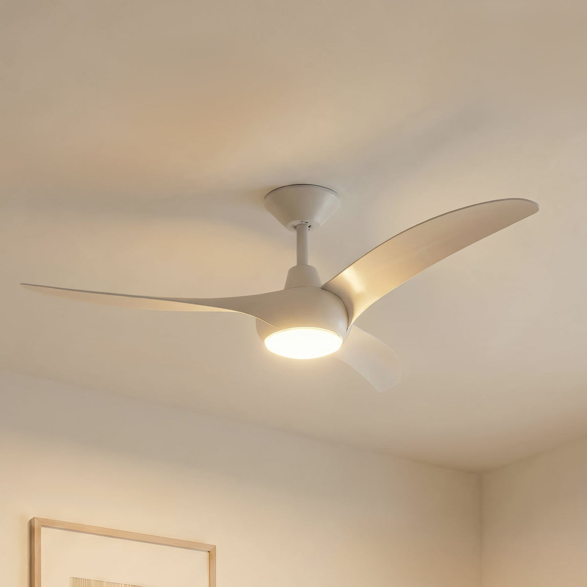 Ventilateur de plafond blanc à trois pales avec éclairage LED intégré, installé dans un salon.