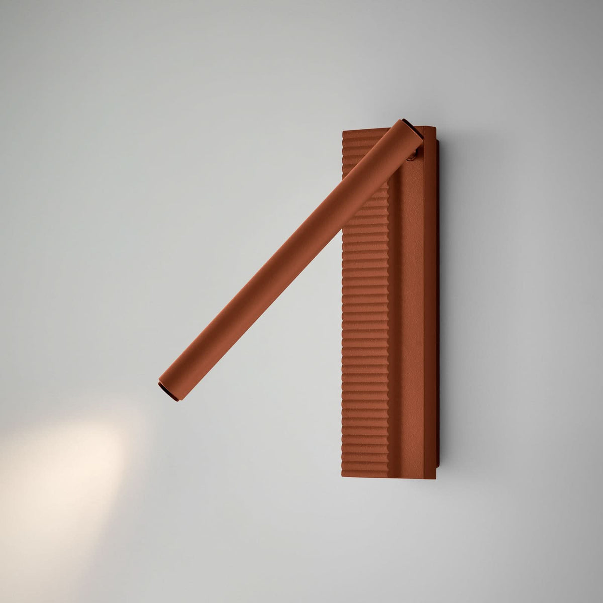 Applique terracotta installée sur mur gris clair, éclairage diffus vers le bas.