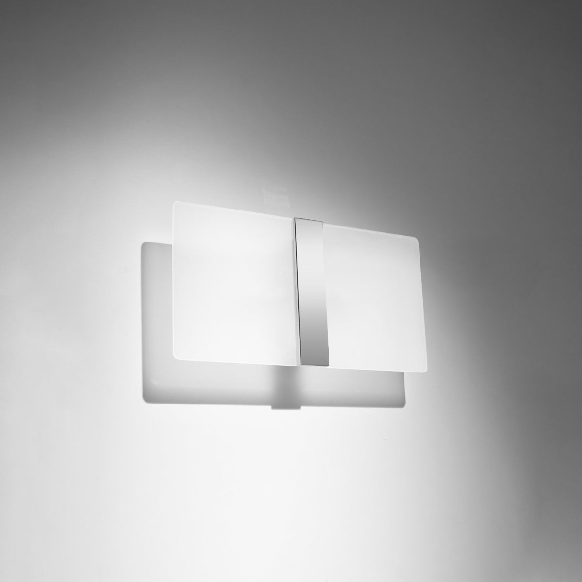 Luminaire allumé sur mur gris, large halo lumineux diffus tout autour