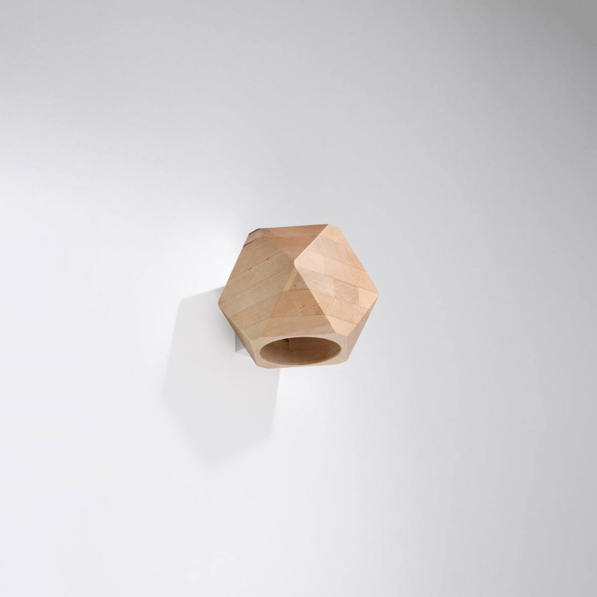 Applique fixée sur un mur blanc, ombre douce, présentation sobre du produit.