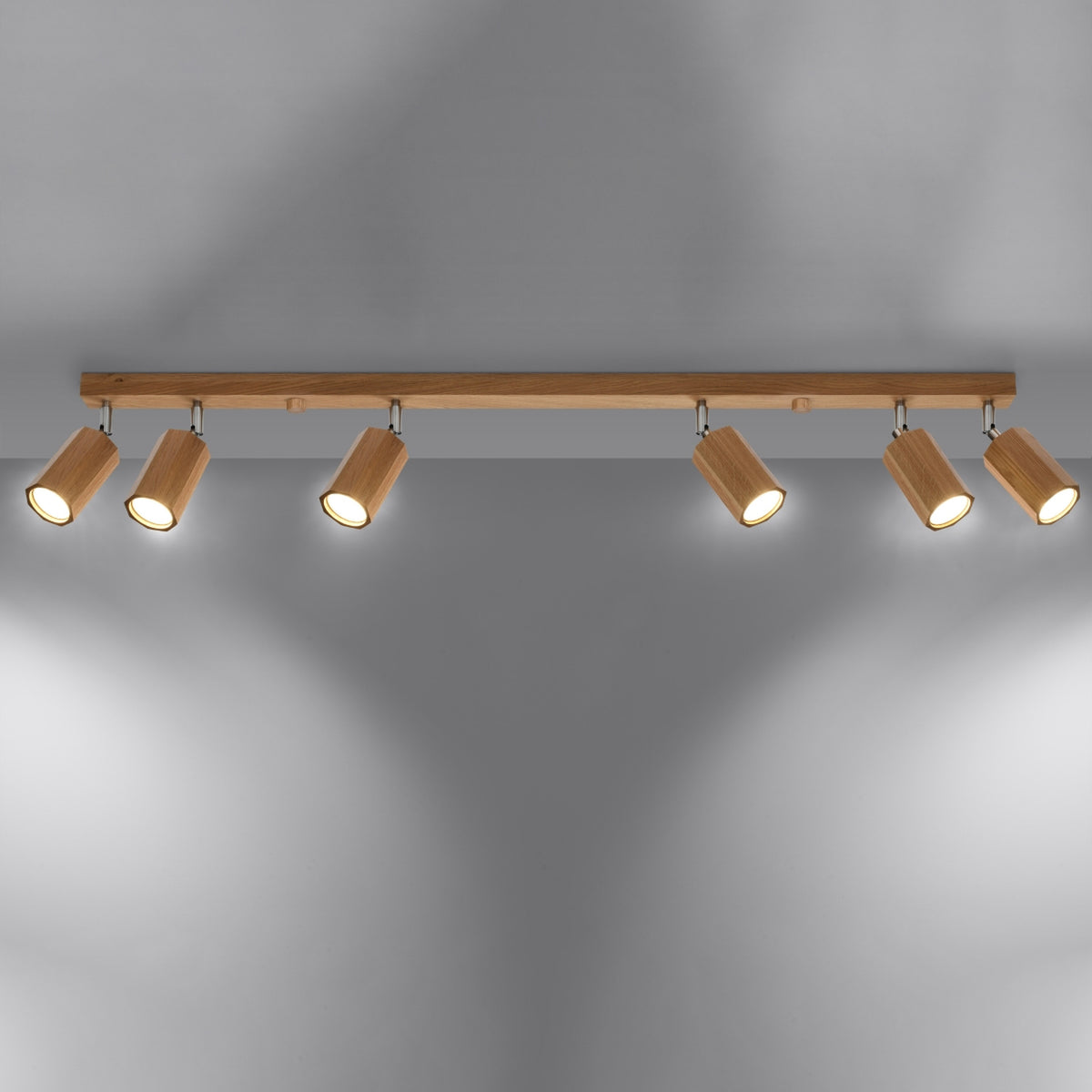 Mise en ambiance du plafonnier allumé, projetant une lumière chaude sur un mur gris.