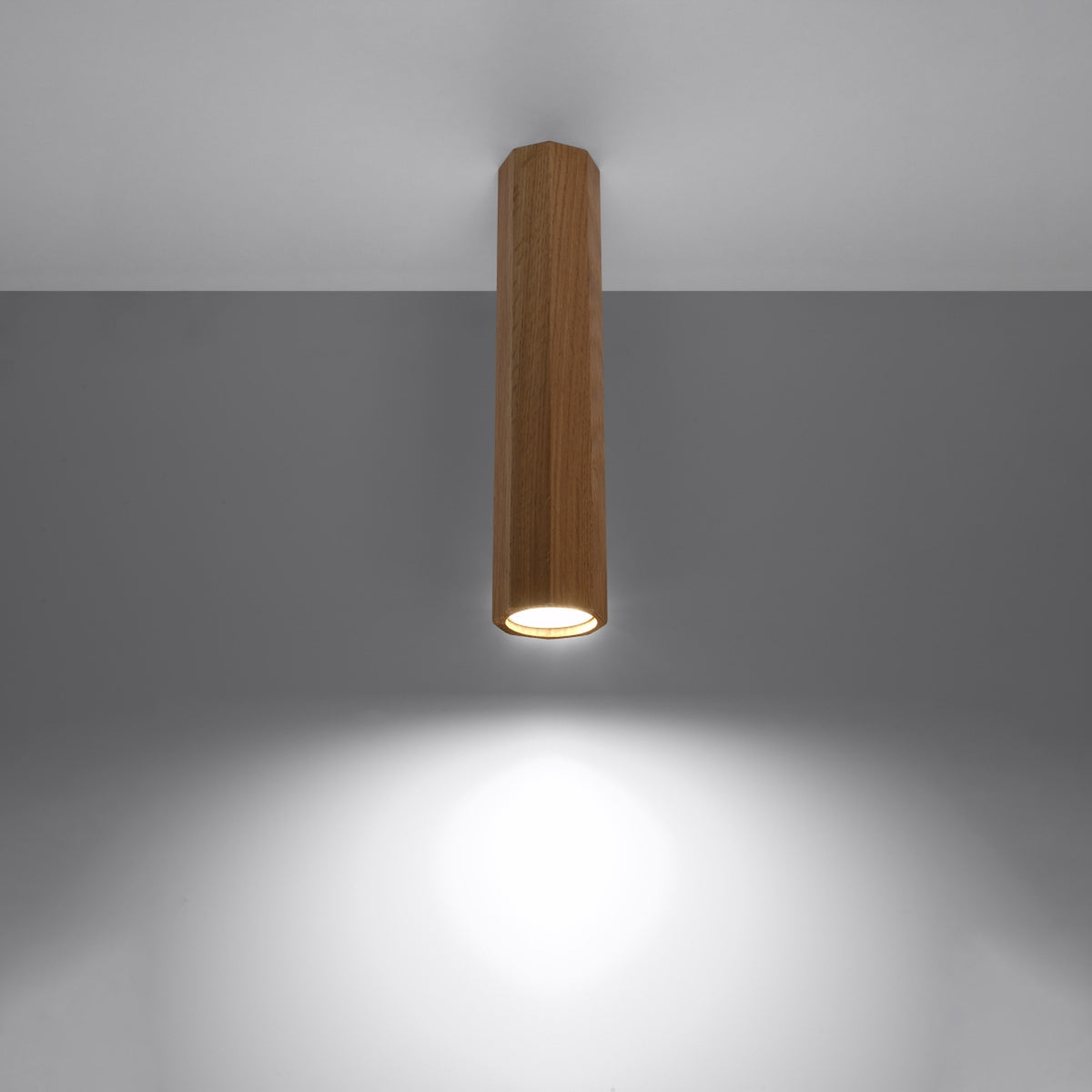 Diffuseur allumé projetant un halo de lumière blanche sur surface grise.