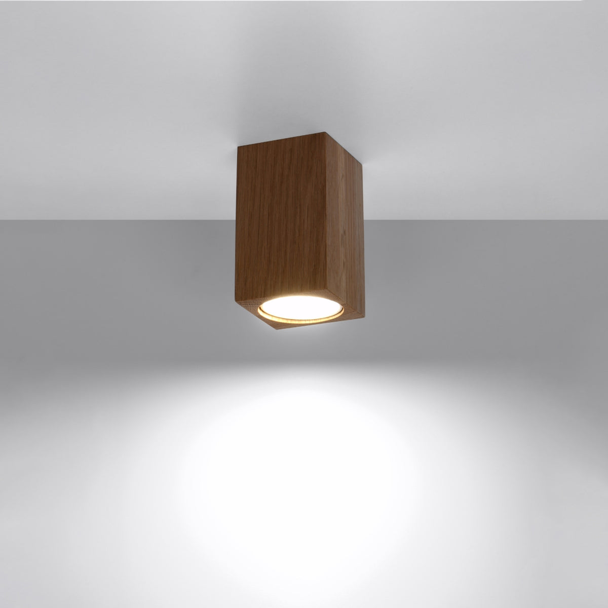 Plafonnier allumé au plafond diffusant un halo lumineux blanc vers le bas
