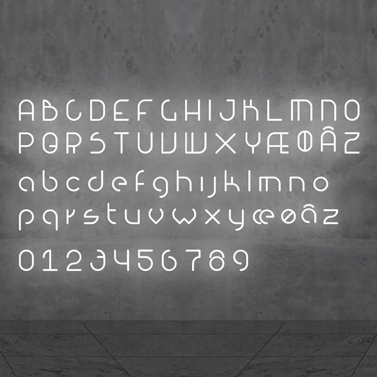 Alphabet et chiffres lumineux blancs disposés sur un mur gris béton.