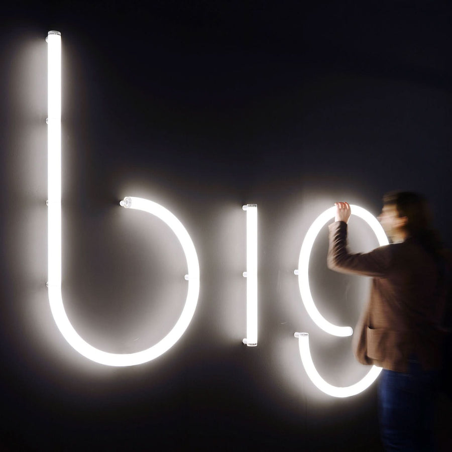 Personne touchant de grandes lettres lumineuses bio sur fond sombre
