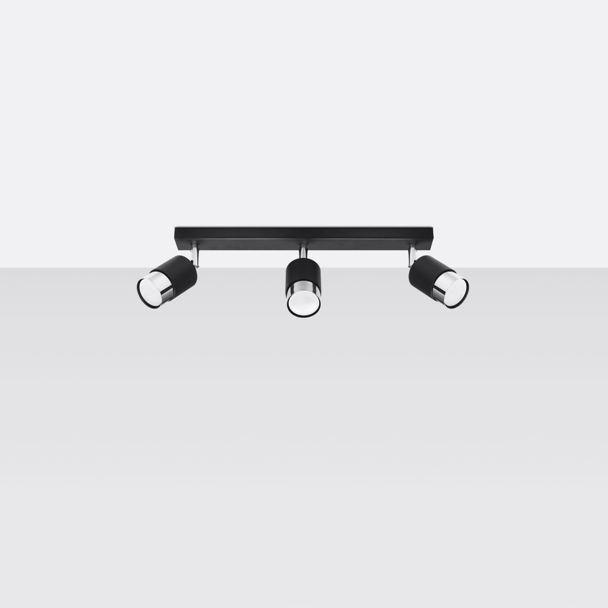 Vue de face du plafonnier à trois spots noirs, barre rectangulaire et diffuseurs chromés orientables.
