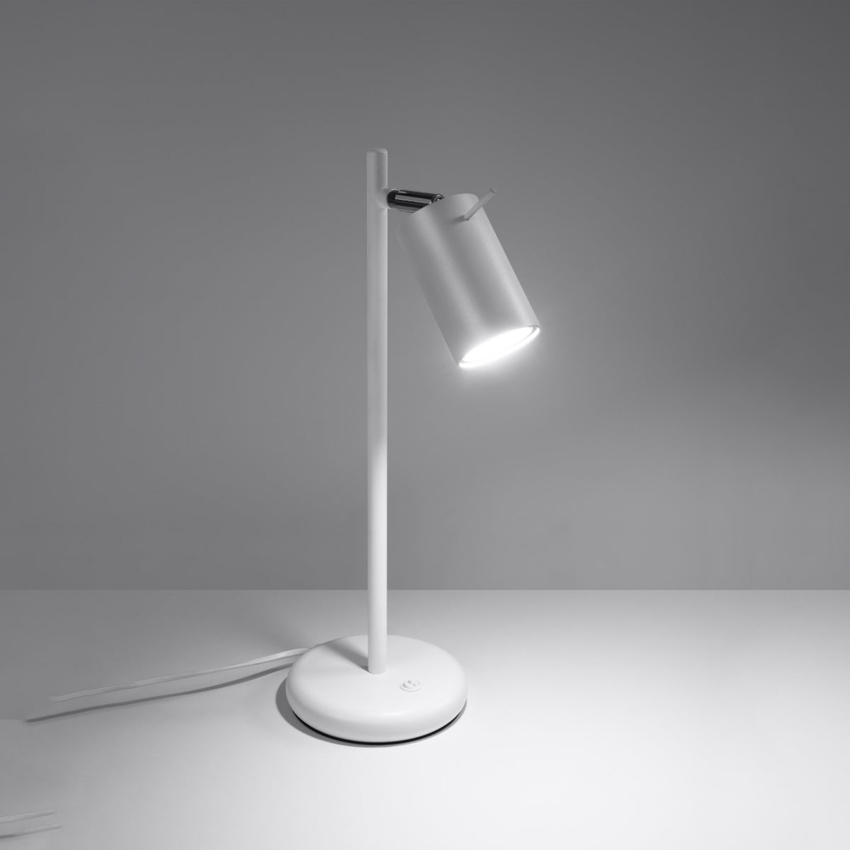 Lampe allumée dans une pièce grise, faisceau lumineux dirigé vers le bas