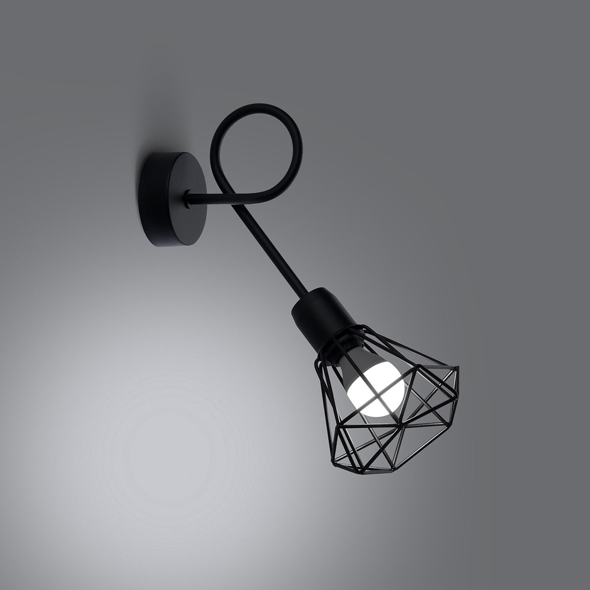 Mise en ambiance montrant l'applique noire allumée projetant une lumière douce sur le mur.