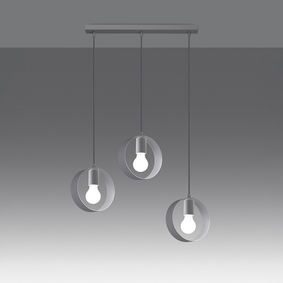 Luminaire allumé sur fond dégradé gris, trois suspensions à cercles blancs.