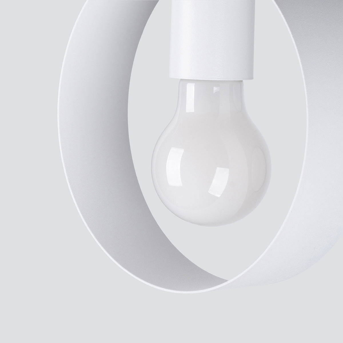 Détail rapproché d'un anneau blanc, ampoule et douille apparentes.