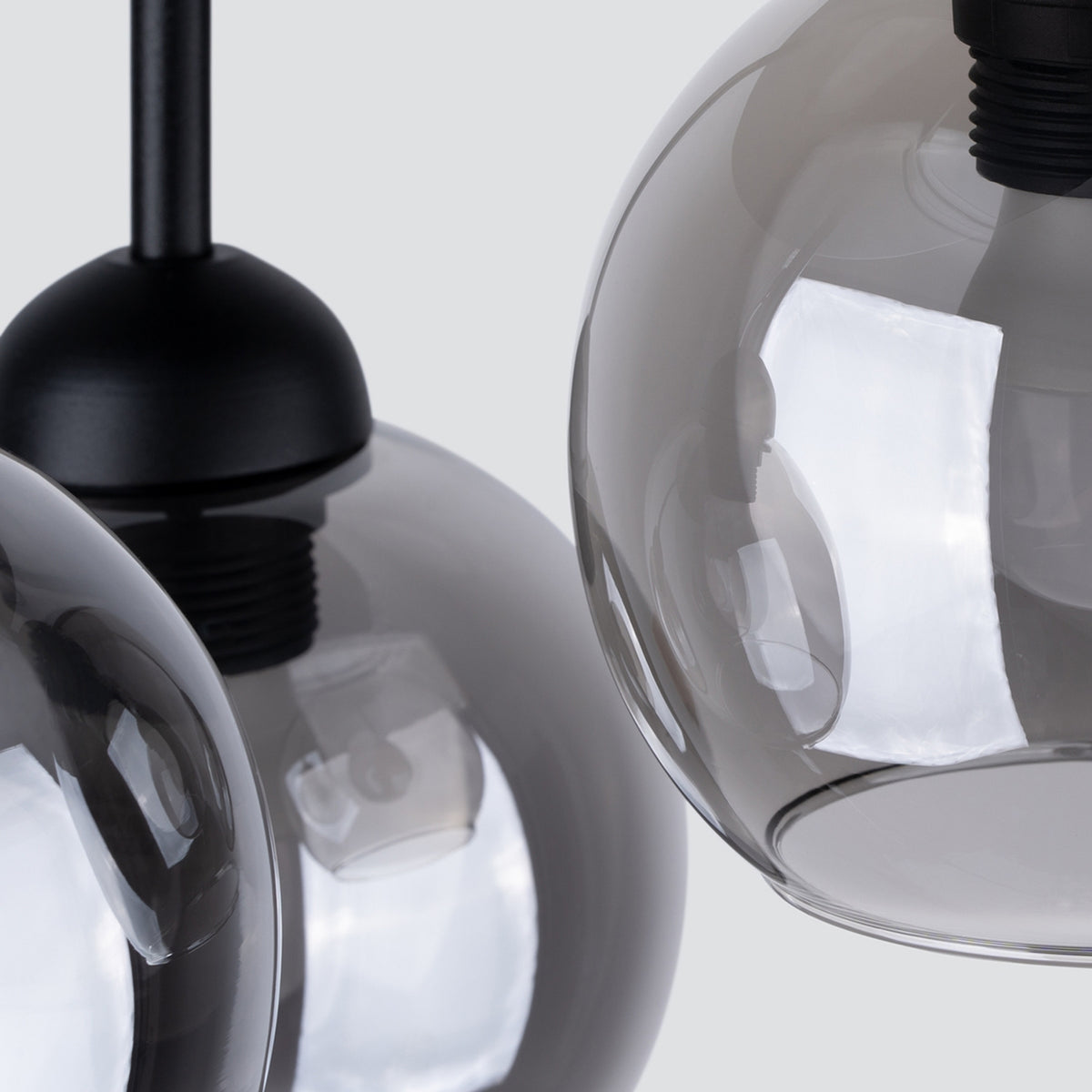 Détail rapproché d'une sphère en verre fumé et de la douille noire fixée sur tige.