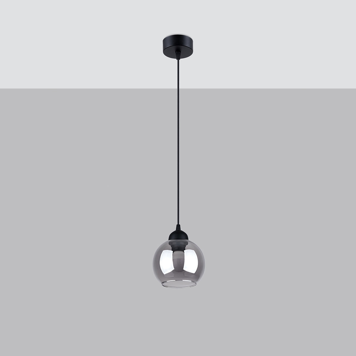 Suspension noire seule sur fond gris clair, câble et rosace visibles.