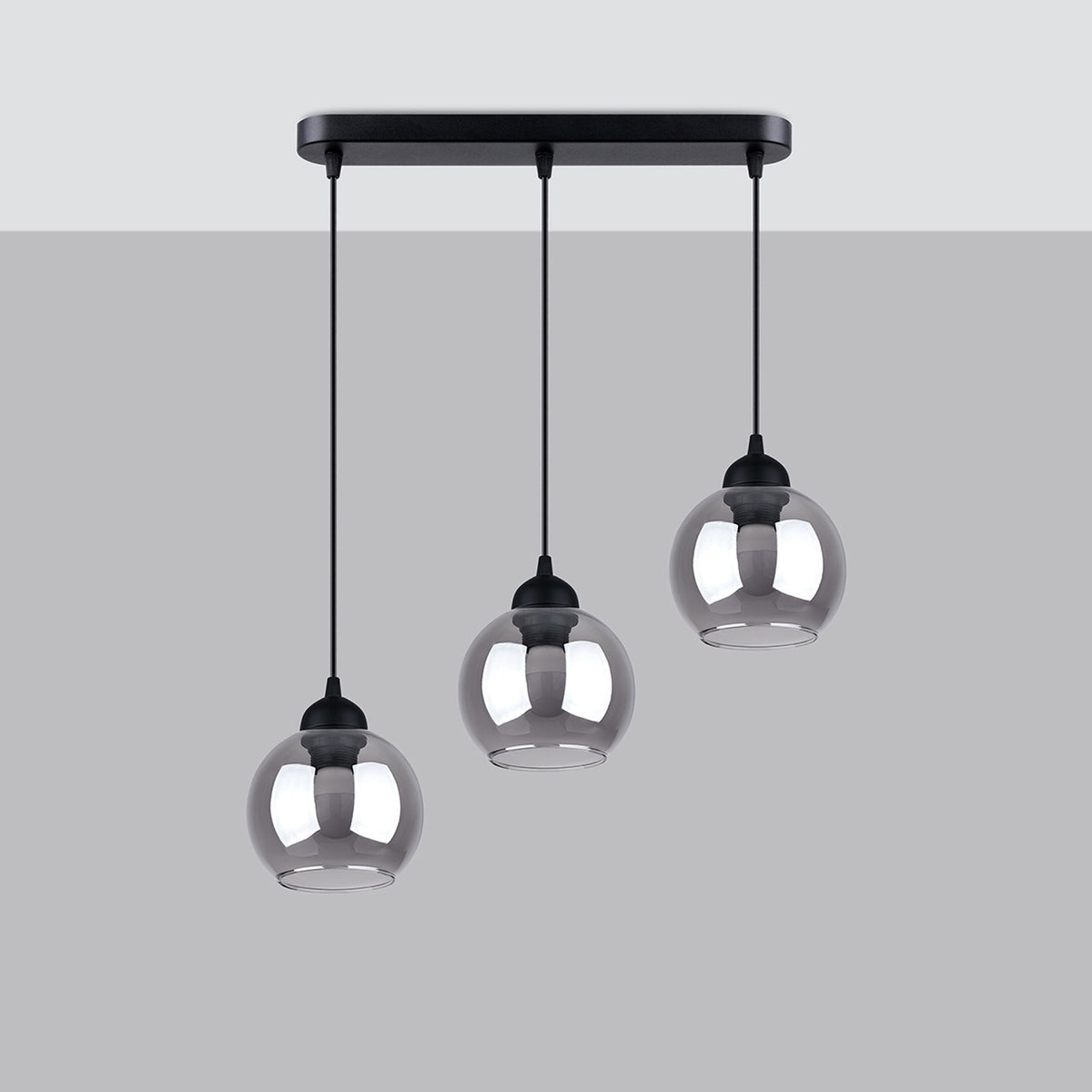 Luminaire suspendu à trois globes en verre fumé, présenté sur fond gris