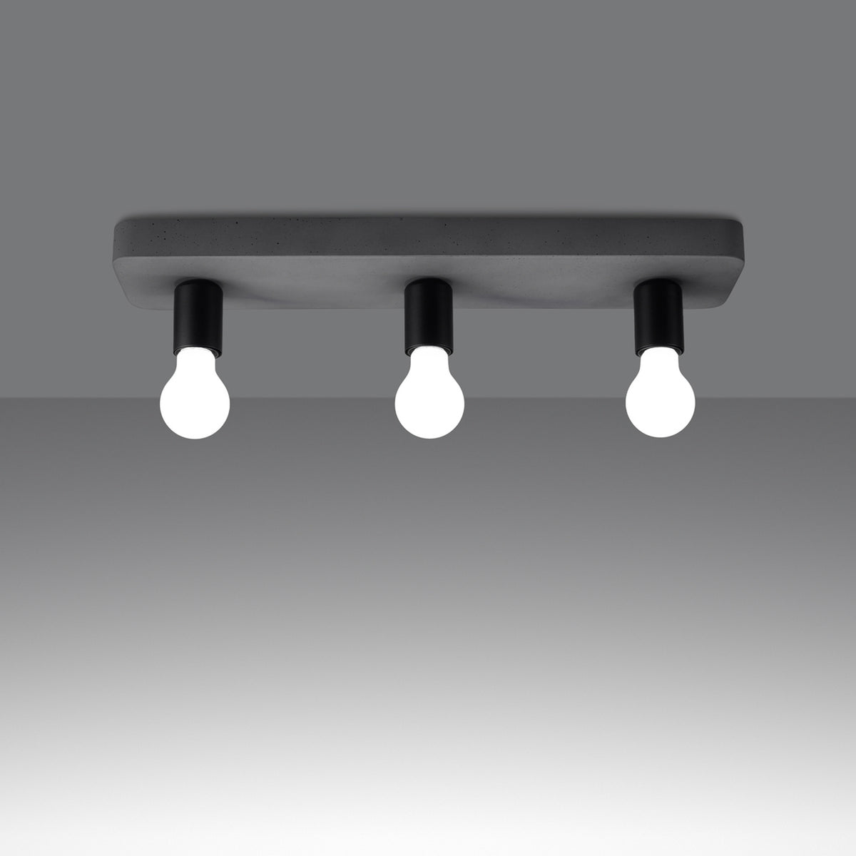 Mise en ambiance sombre montrant le plafonnier allumé avec trois sources lumineuses.