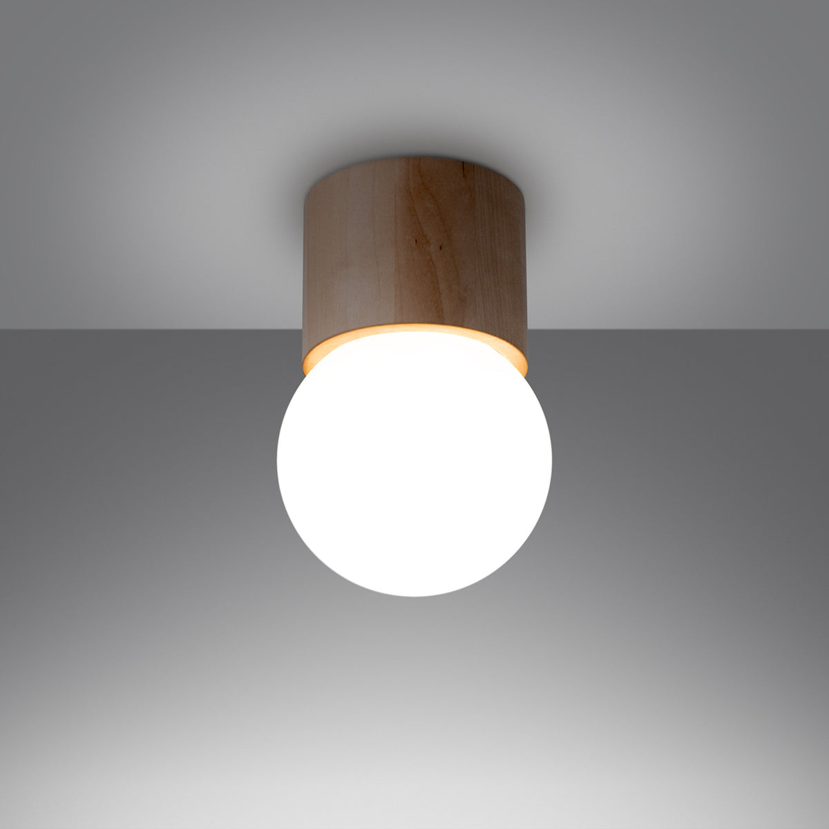 Plafonnier allumé diffusant une lumière chaude dans une pièce grise