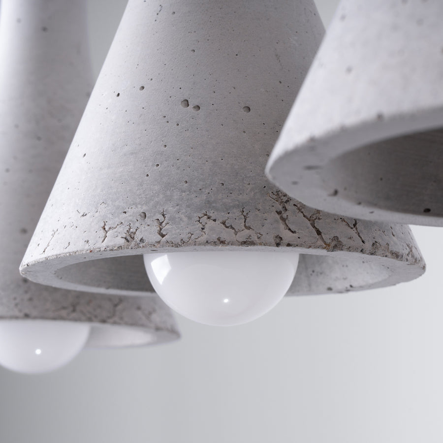 Gros plan sur la texture brute du béton et l'ampoule blanche à l'intérieur.