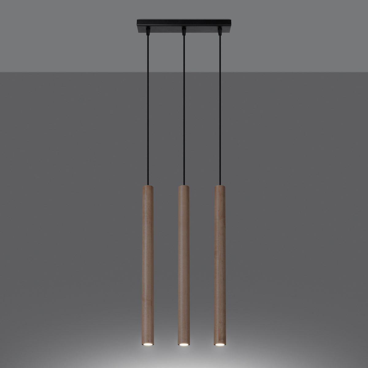 Mise en ambiance sombre, les trois cylindres bois diffusent une lumière chaude vers le bas.