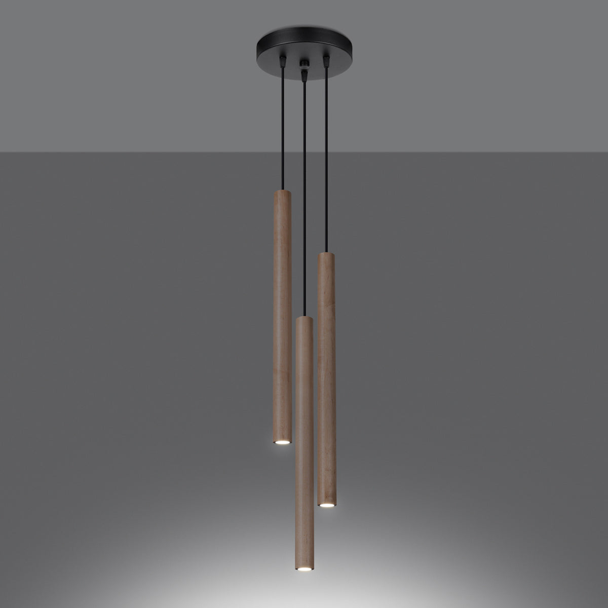 Suspension allumée en ambiance sombre, les trois tubes diffusent une lumière vers le bas.