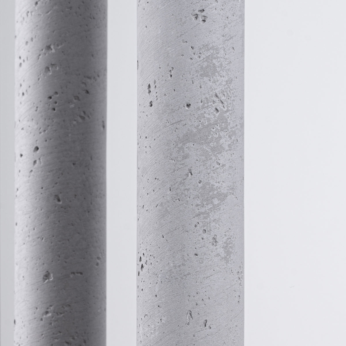 Gros plan sur la texture brute et poreuse du béton d'un cylindre.