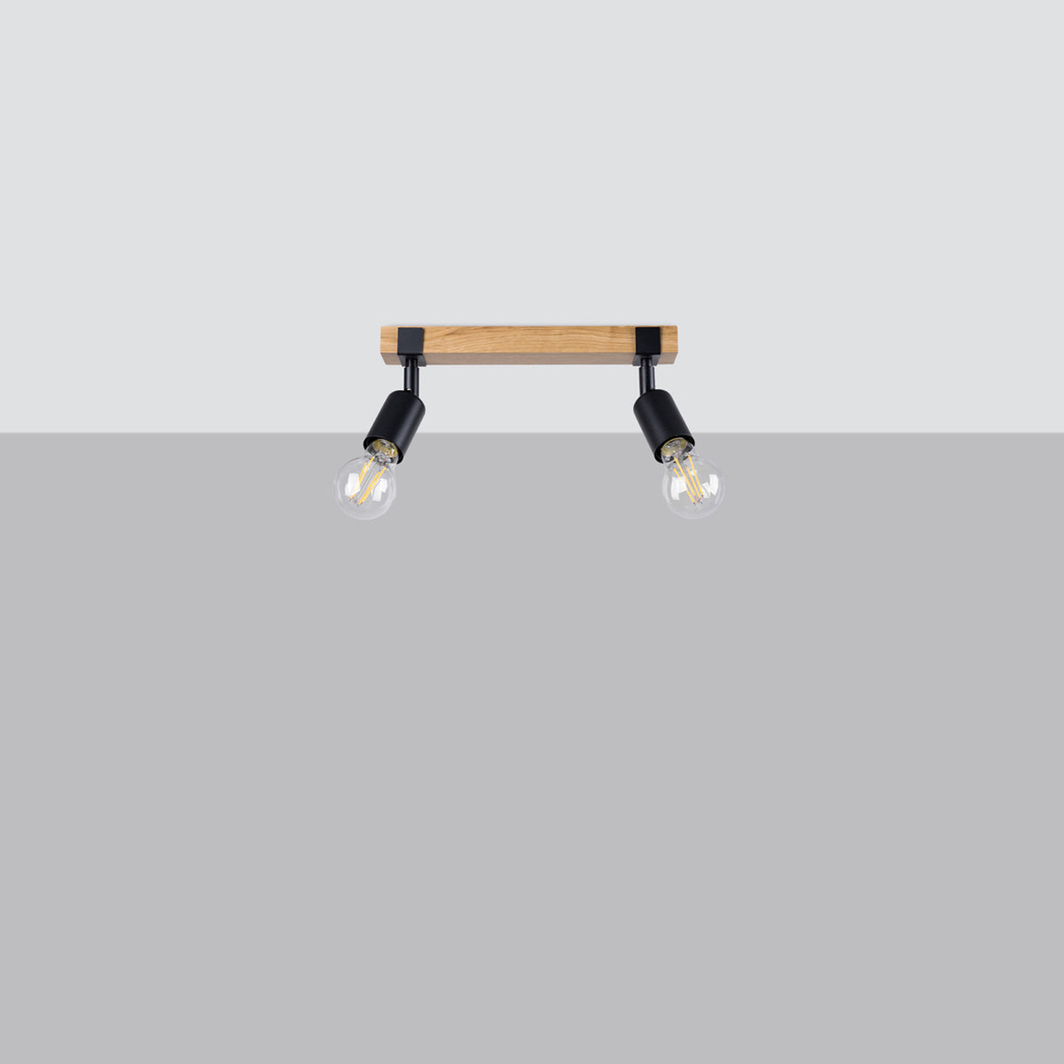 Vue de face du luminaire sur fond gris, deux projecteurs orientables et ampoules.