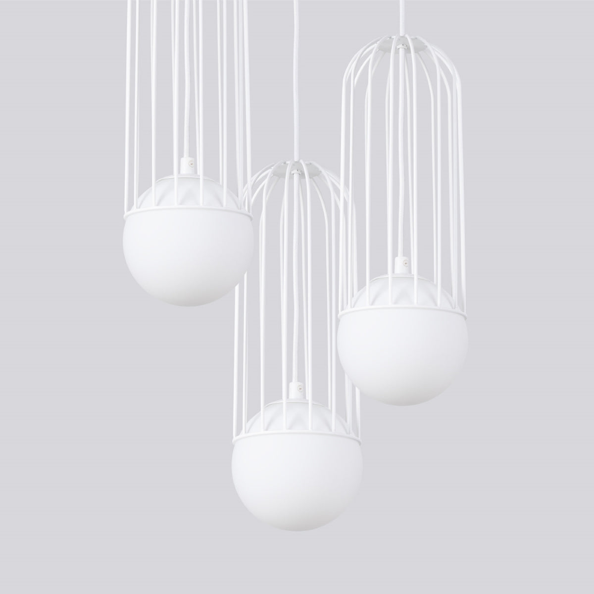 Gros plan sur les cages métalliques et les diffuseurs sphériques du luminaire éteint