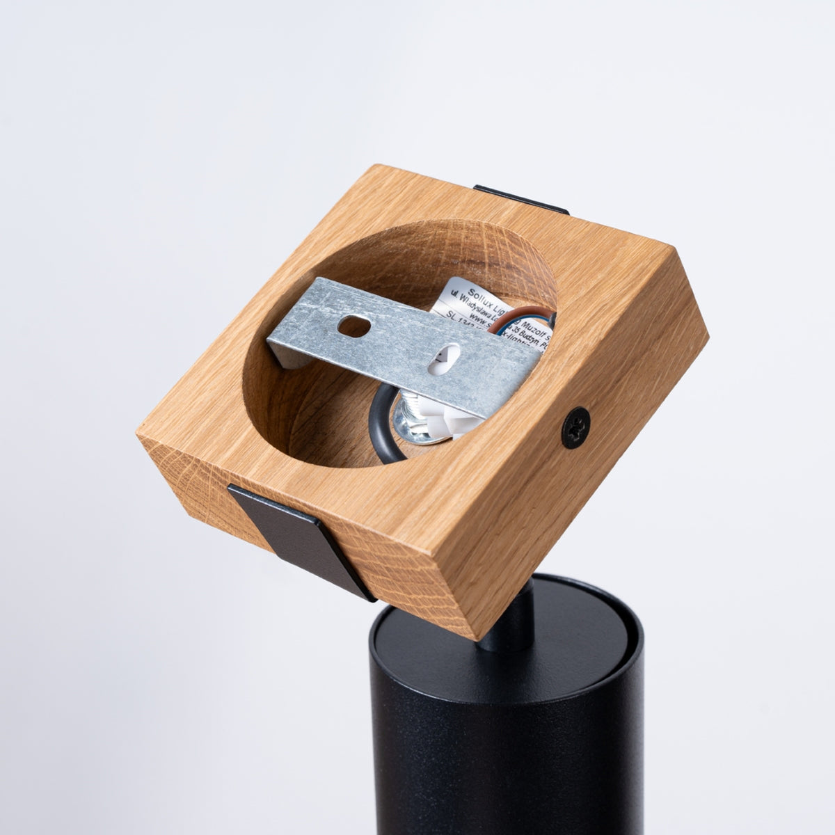 Détail du dos en bois évidé avec platine métallique, câblage et fixation apparents