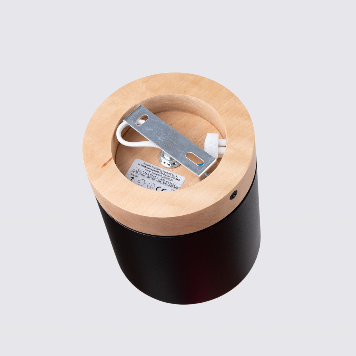 Dessous du boîtier en bois, platine métallique et étiquette produit