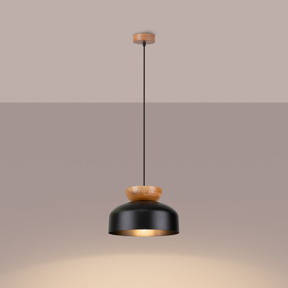 Lampe suspendue allumée diffusant une lumière chaude sous l'abat-jour noir.