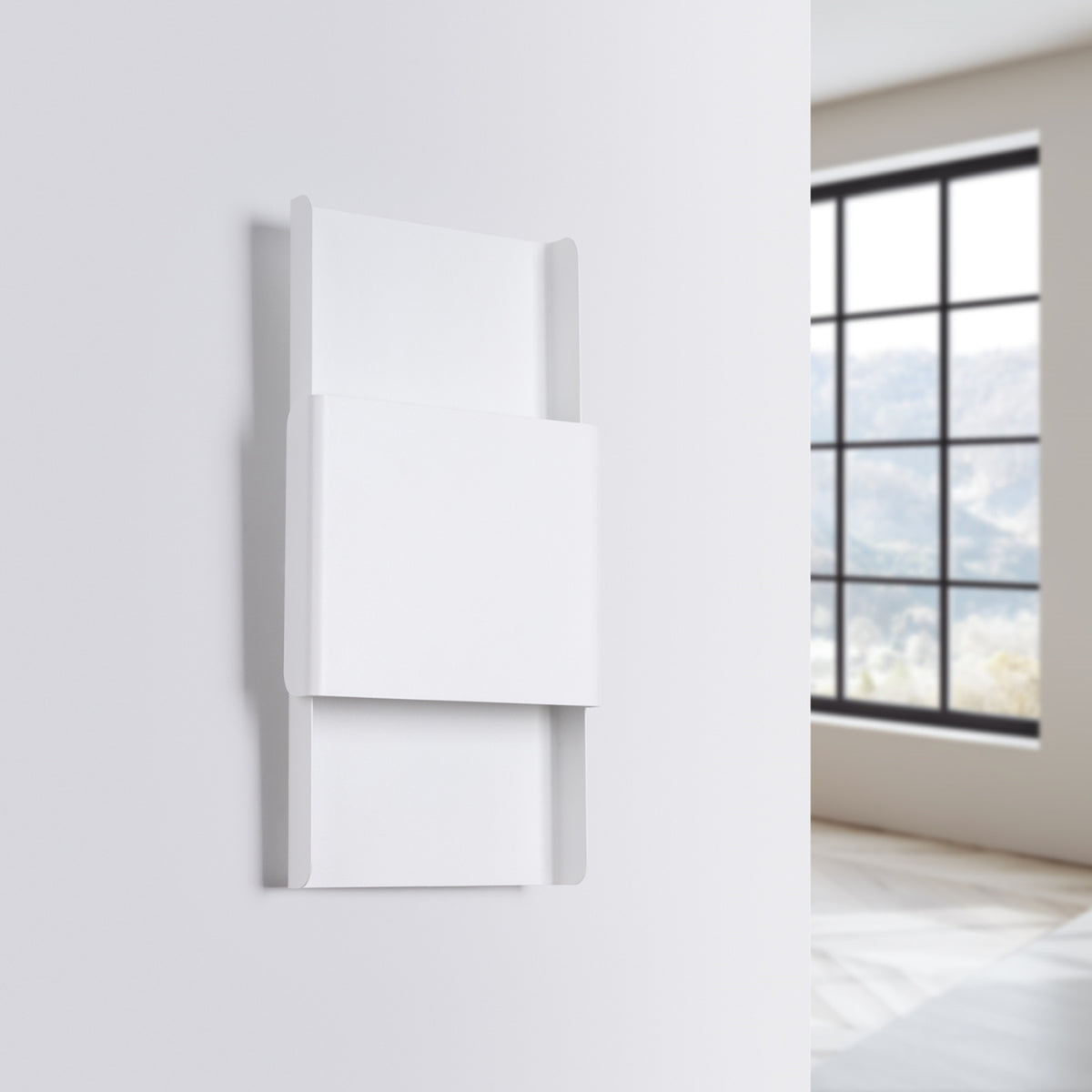Vue de trois quarts de l'applique blanche installée sur un mur, intérieur avec fenêtre