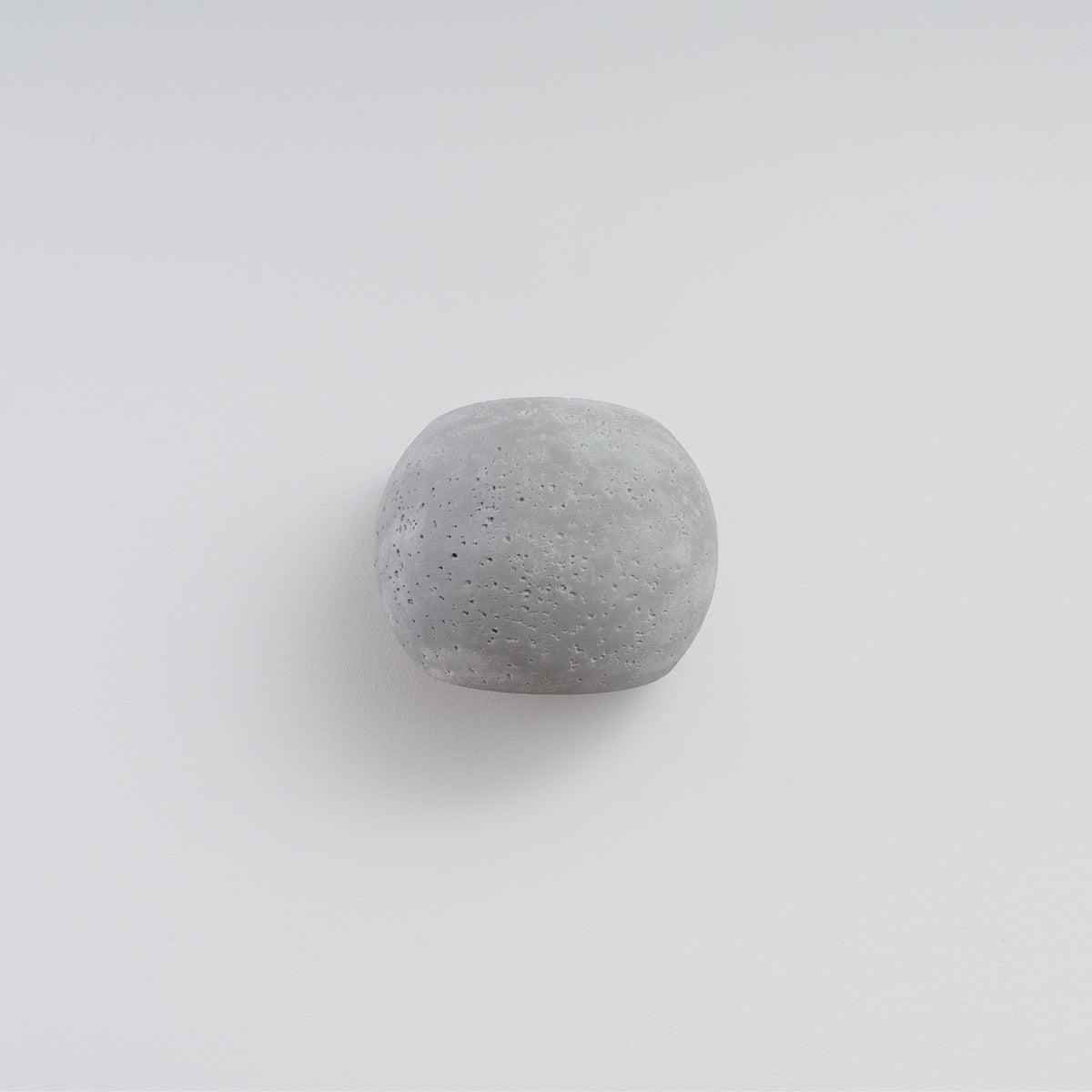 Vue de face de l'applique ronde en béton sur fond blanc