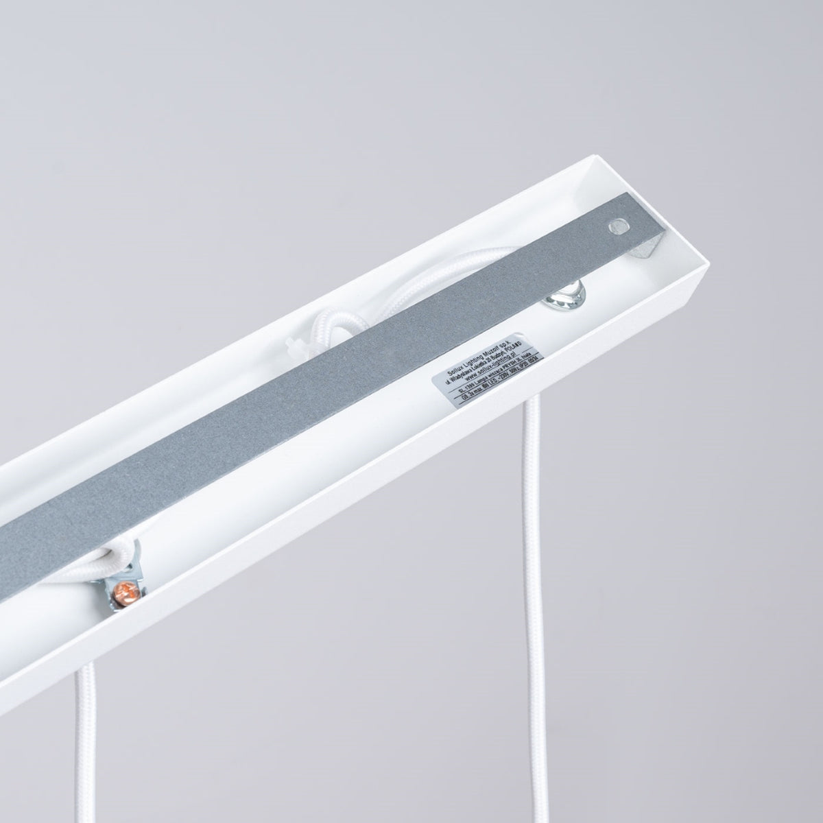 Détail de la platine de fixation et de l'étiquette constructeur à l'intérieur de la barre blanche