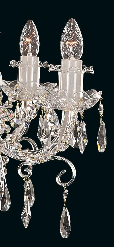Gros plan sur les douilles, bougies et pendeloques en cristal du luminaire