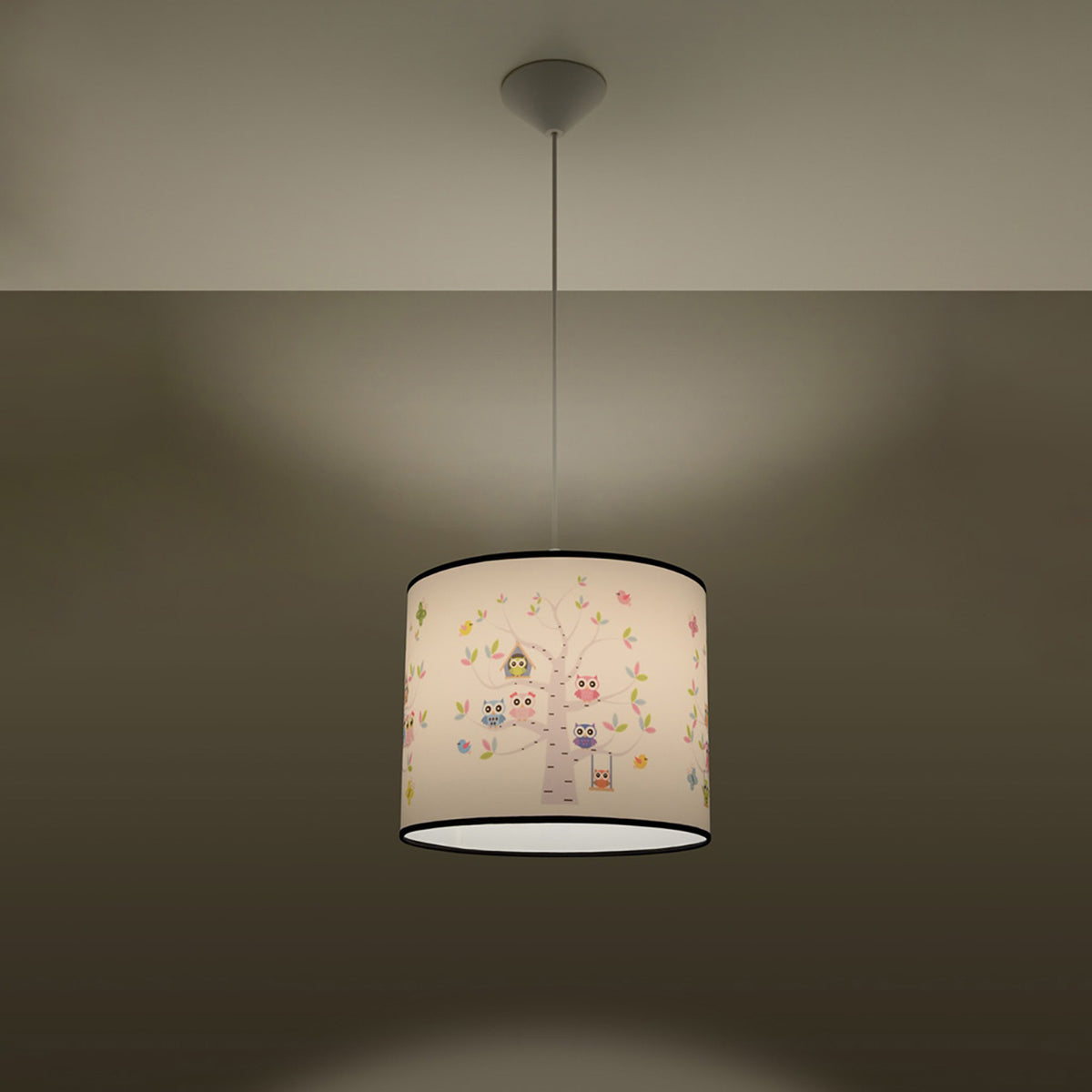 Luminaire allumé dans une pièce sombre, abat-jour illuminé diffusant une lumière chaude.