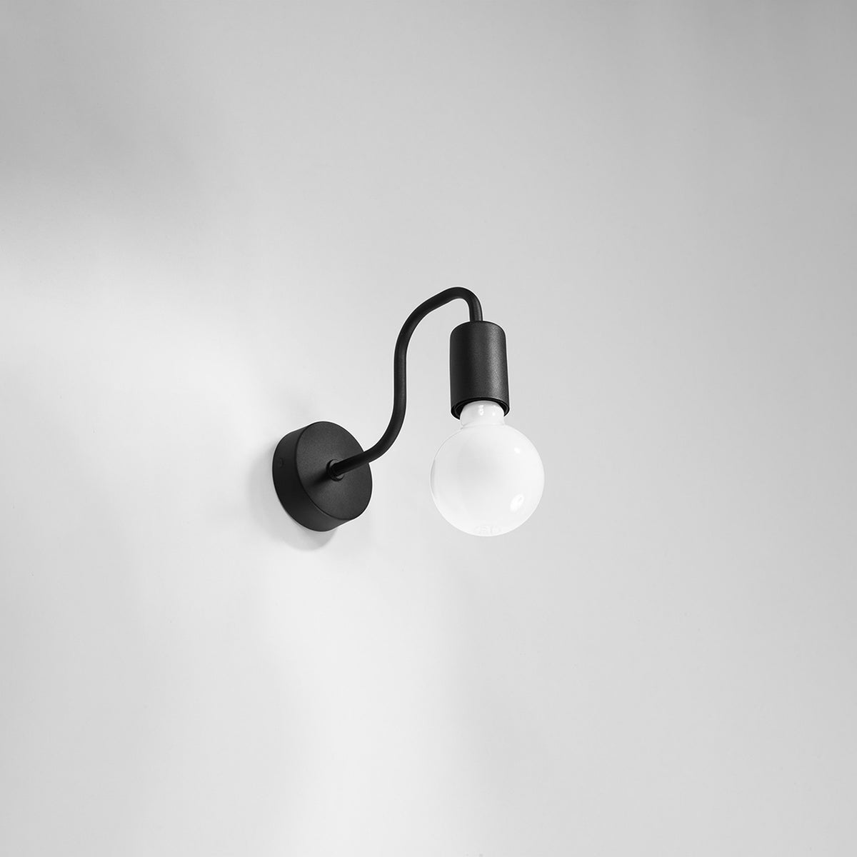 Applique murale noire avec ampoule globe blanche éteinte sur fond clair