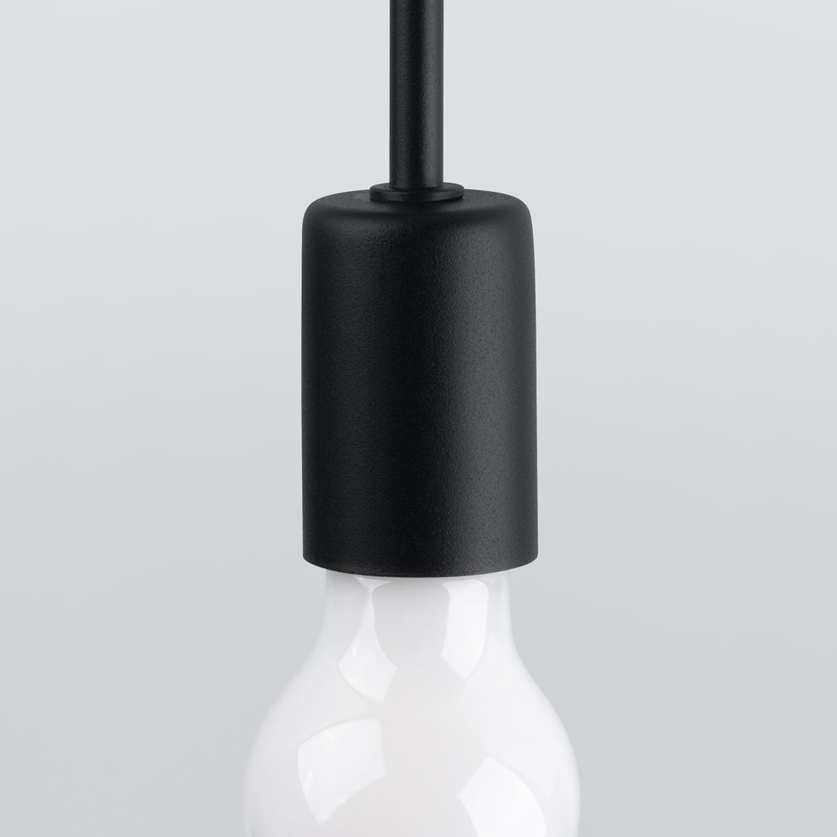 Gros plan sur la douille cylindrique noire et le haut de l'ampoule blanche, détail de finition.