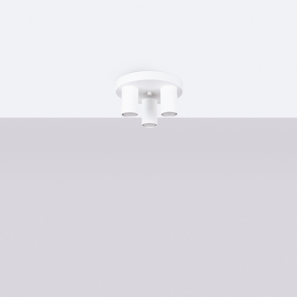 Luminaire blanc installé au plafond d'une pièce claire et vide