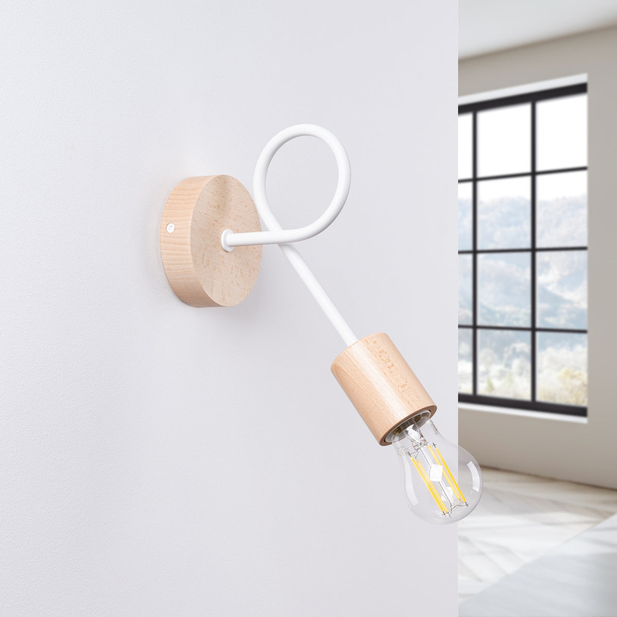 Applique murale installée sur un mur blanc, près d'une fenêtre, lumière naturelle.