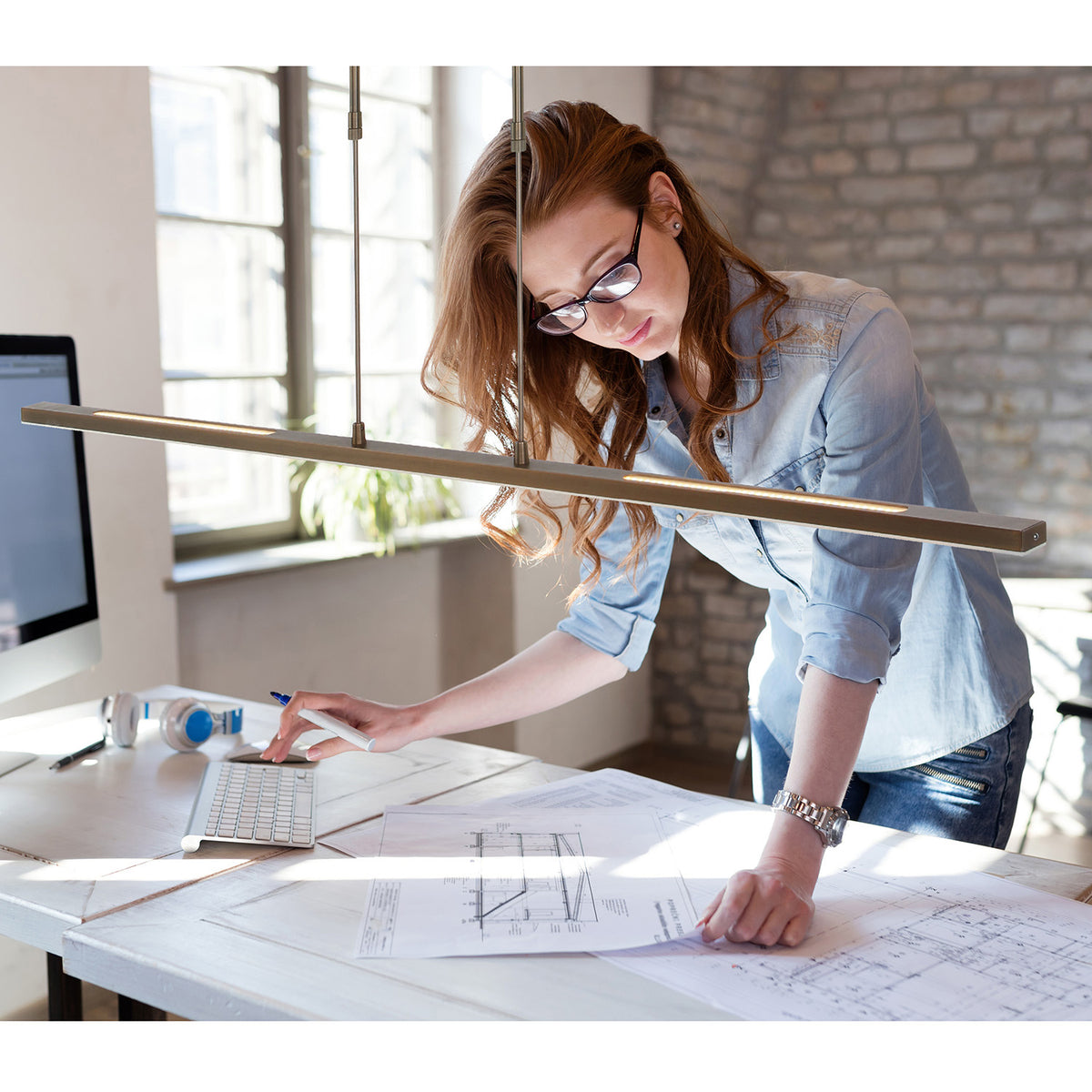 Mise en ambiance au-dessus d'un bureau, femme travaillant sur des plans